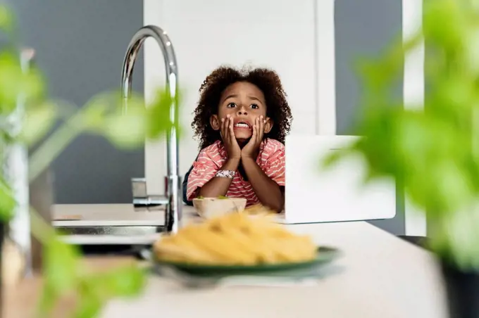 Girl with laptop in kitchen