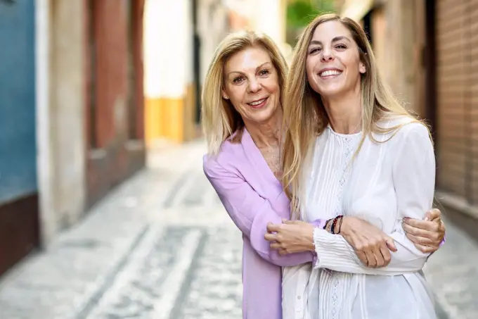 Happy mature woman with her daughter in the city