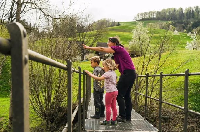 Mother with two children on a bridge in the countryside
