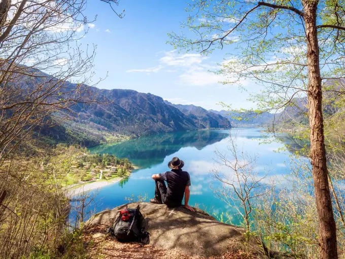 Italy, Lombardy, spring at Lake Idro, hiker sitting on observation point