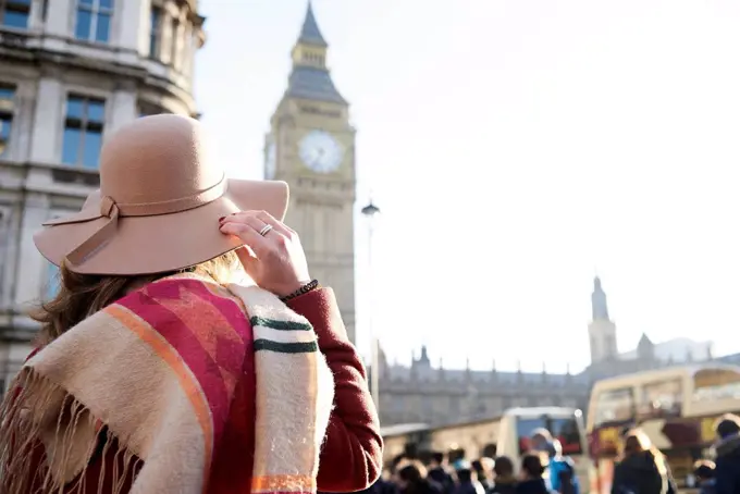 UK, London, rear view of woman wearing a floppy hat looking at Big Ben