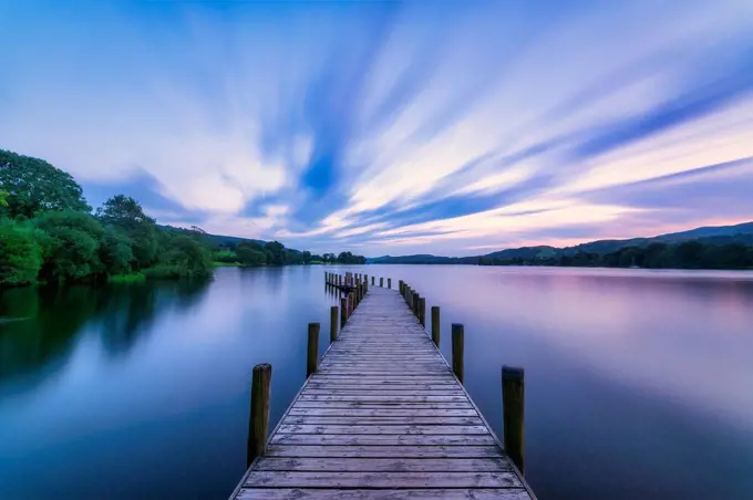 UK, England, Long exposure of clouds over jetty on¶ÿConiston Water lake at dusk