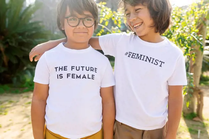 Two boys standing in the street with print on t-shirt, saying femininst and the future is female