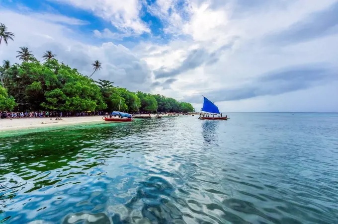 Papua New Guinea, Trobriand Islands, Kitava Island, beach with tourists and boats