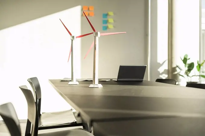 Wind turbine models and laptop on desk in office