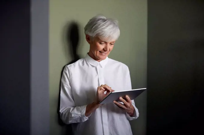Portrait of senior businesswoman using digital tablet