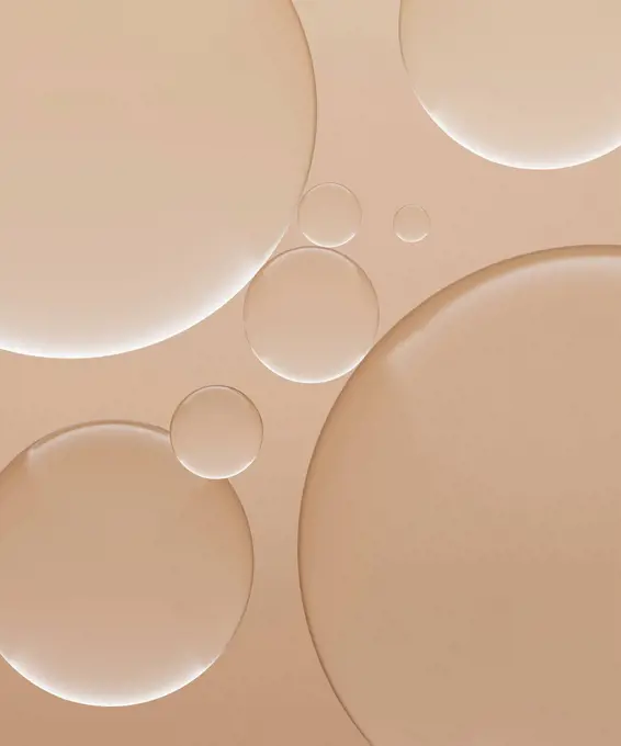 Three dimensional render of transparent glass spheres against light brown background