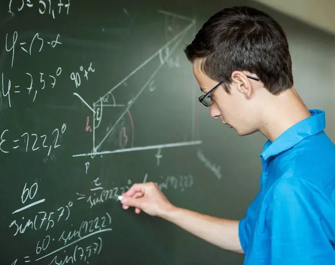 Austria, Student calculating at blackboard