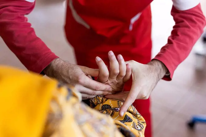 Male nurse giving massage to disabled woman's fingers at rehabilitation center