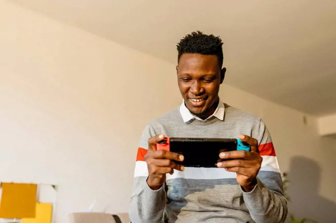 Male entrepreneur playing video game at home during break from work