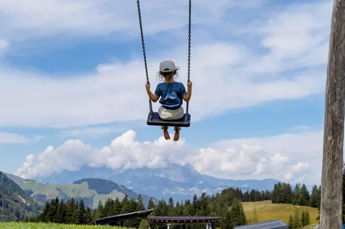 Little girl playing on swing