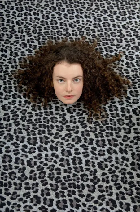 Studio shot of head of teenage girl sticking out of leopard print