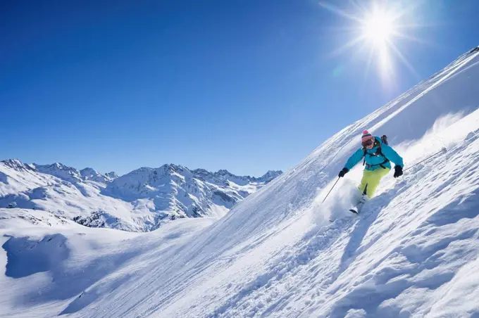 Sun shining over woman skiing in Arlberg massif