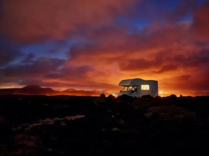 Spain, Canary Islands, Motor home parked along rocky coast of Lanzarote island at sunset