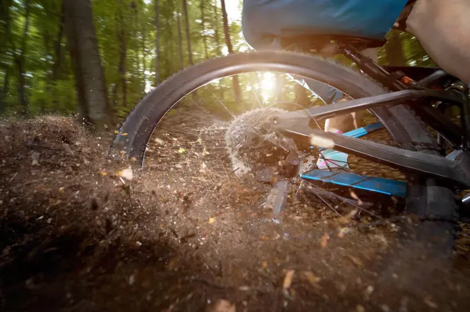 Rear wheel of bicycle drifting in dirt road at forest