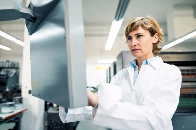 Female scientist operating printing machine in laboratory
