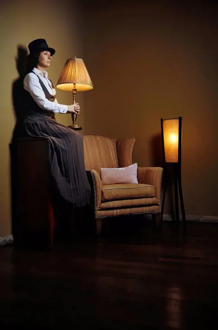 Woman holding lamp in darkroom