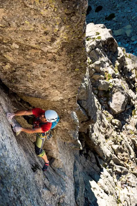 Male climber moving up on rocky mountain