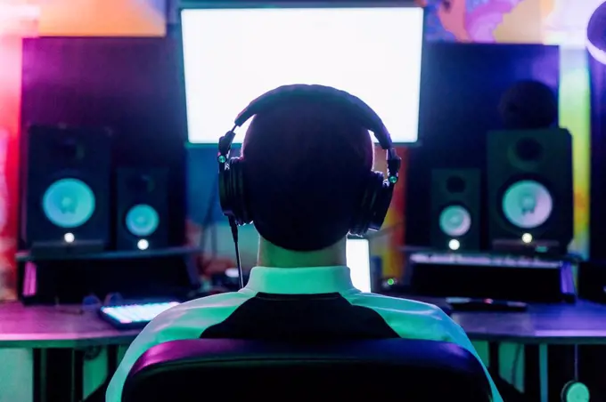 Male composer listening music while composing at home studio