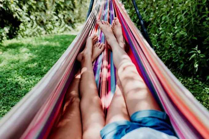 Girls lying in hammock on sunny day