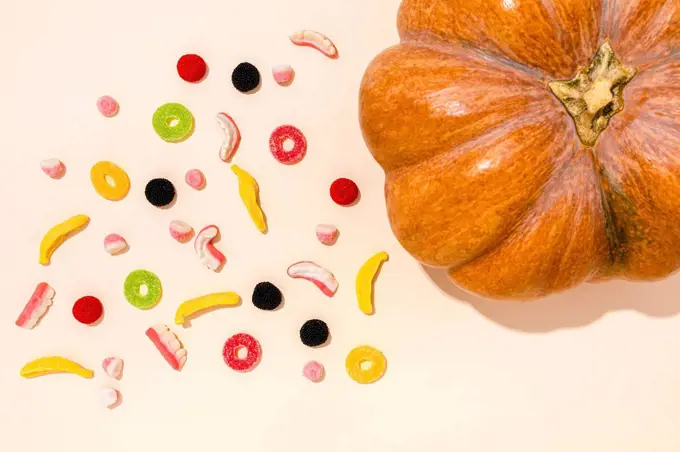 Studio shot of raw pumpkin and various Halloween candies