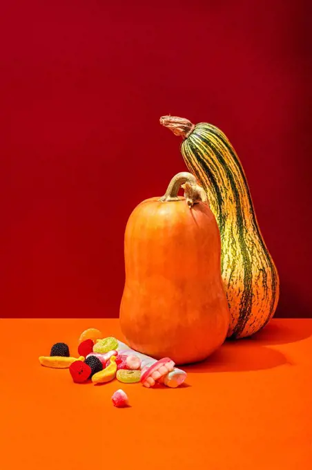 Studio shot of two raw pumpkins and Halloween candies