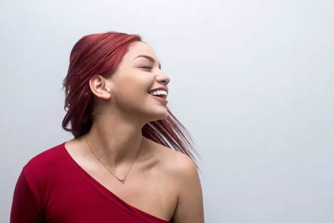 Redhead woman tossing hair in front of white background