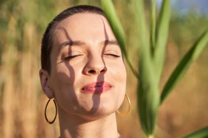 Beautiful young woman with eyes closed during sunny day