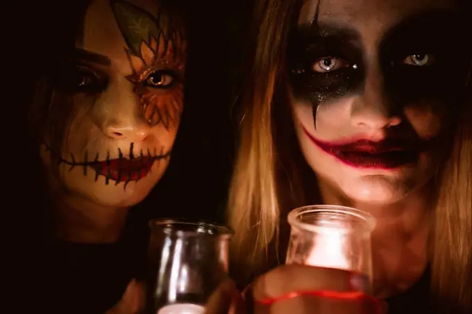 Women with Halloween make-up holding illuminated equipment