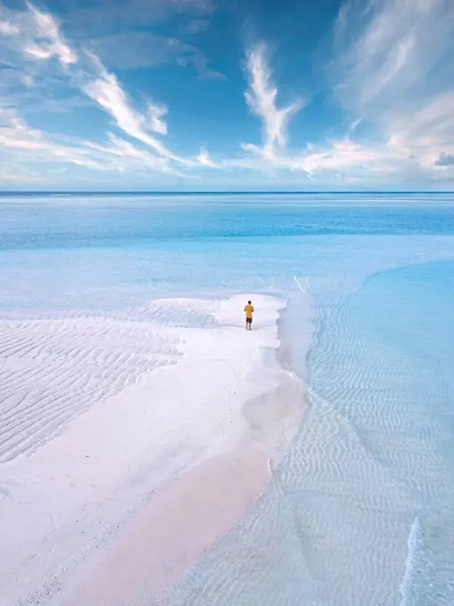 Aerial view of lone man standing on sandy coastal beach of Thulusdhoo island