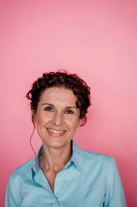 Smiling businesswoman over pink background