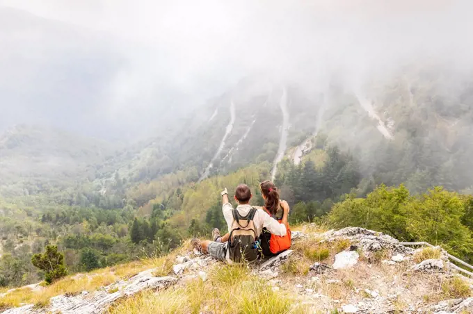 Italy, Massa, couple looking at the beautiful view in the Alpi Apuane