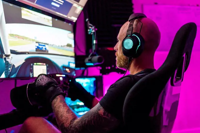Mid adult male gamer playing video game at studio
