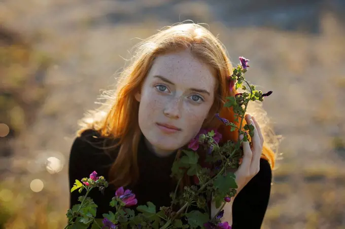 Redhead woman with flowering plant