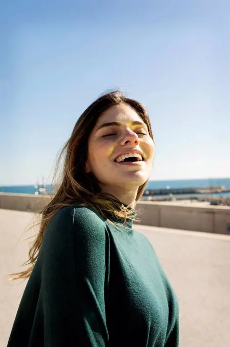 Happy woman with eyes closed during sunny day