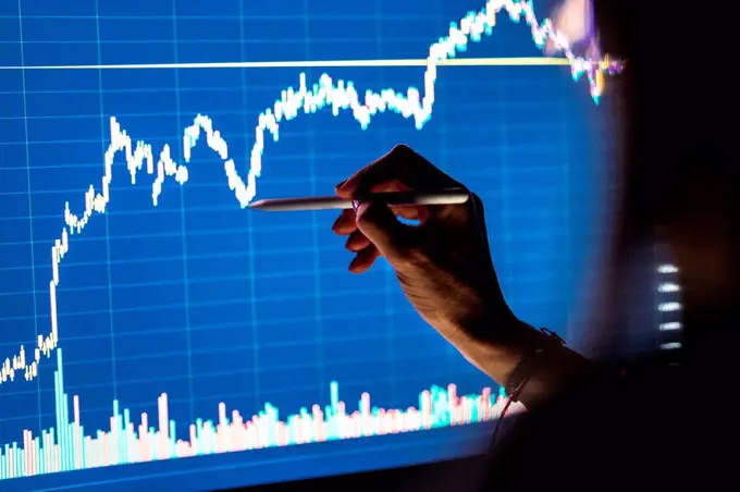 Female business professional checking stock market graph on screen