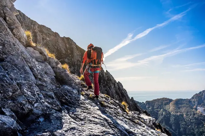 Male alpinist hiking on adventurous mountain trail