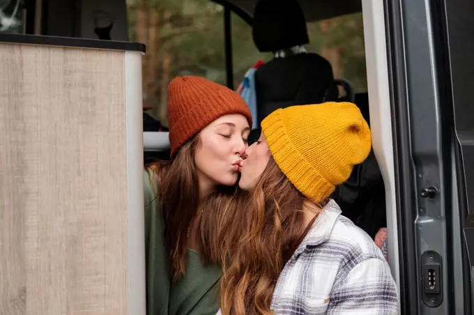 Affectionate lesbian couple kissing in van