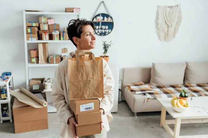 Contemplative owner with package orders standing at store