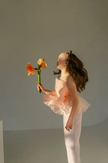 Cute girl jumping with flowers in hand