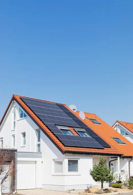 Germany, North Rhine-Westphalia, Solar panels on tiled roofs of modern suburban house