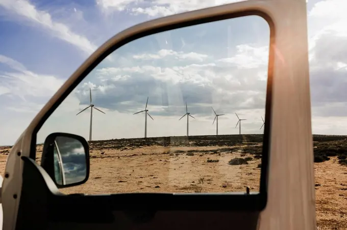 Wind turbines in wind farm seen through van window