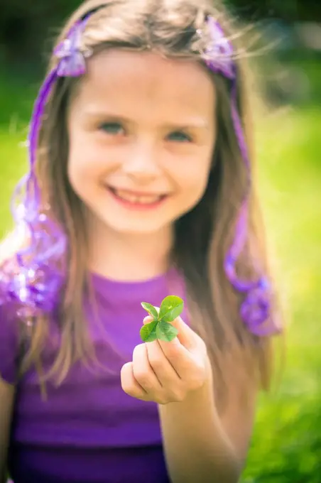 Little girl showing four leaved clover