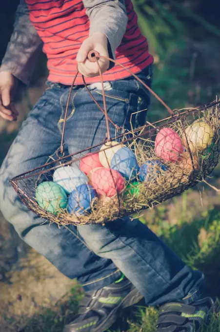 Boy in garden carrying Easter basket