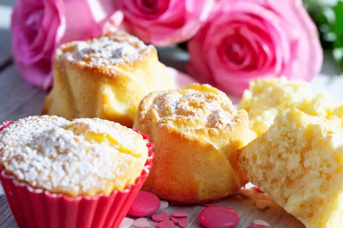 Muffins and pink roses on table