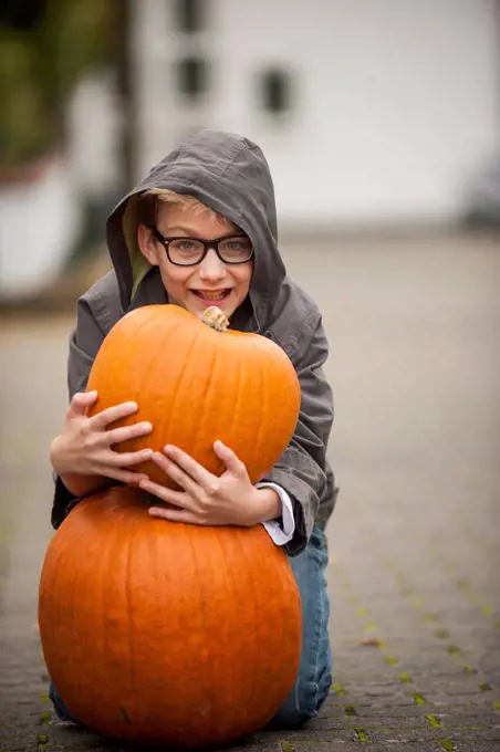 Smiling boy with two big pumpkins