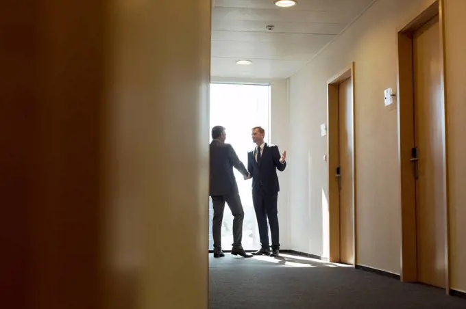 Businesspeople in corridor shaking hands