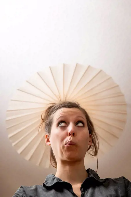 Woman under ceiling lamp as hat
