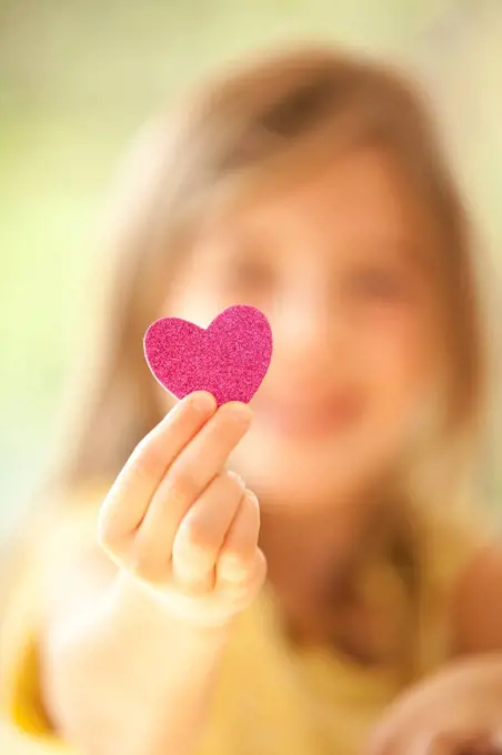 Close-up of girl holding glittering heart