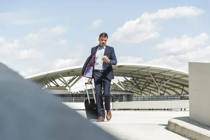 Businessman on business trip arriving with trolley
